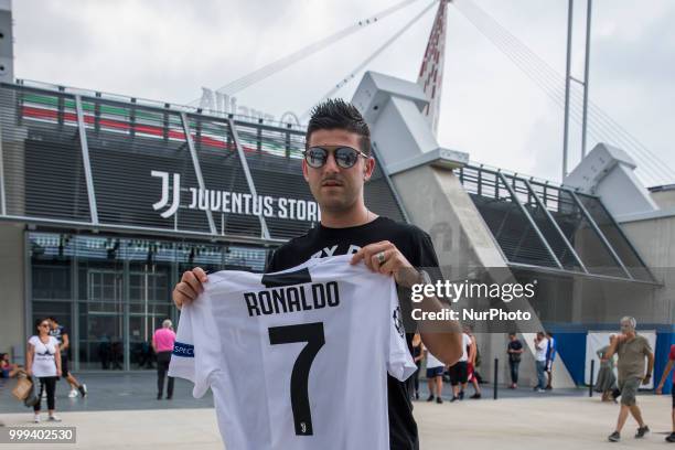 Supporter of Juventus FC poses with Cristiano Ronaldo's Juventus official jersey in front of the Juventus Store, in Turin, Italy, on July 14, 2018...