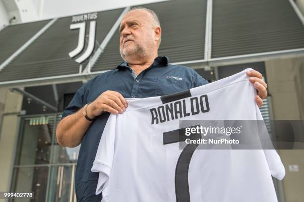 Supporter of Juventus FC poses with Cristiano Ronaldo's Juventus official jersey in front of the Juventus Store, in Turin, Italy, on July 14, 2018...
