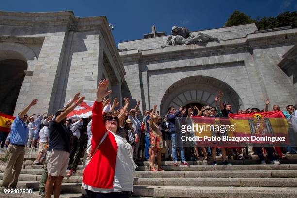Far right-wing supporters do fascist salutes as they hold pre-constitutional Spanish flags during a gathering at El Valle de los Caidos under the...