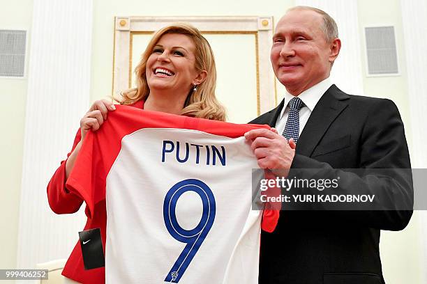 Croatian President Kolinda Grabar-Kitarovic offers to Russian President Vladimir Putin a jersey of the Croatian national football team bearing the...