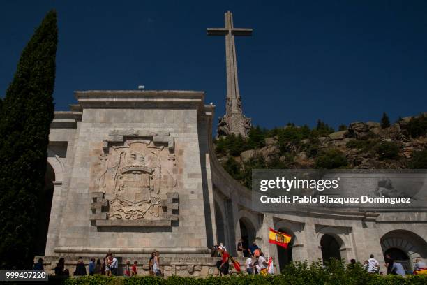 Far right-wing supporter holds a pre-constitutional Spanish flag as he walks past a Spanish coat of arms from Franco's period during a gathering at...