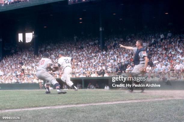 Paul Foytack of the Detroit Tigers runs to first after bunting as catcher Dick Brown of the Cleveland Indians shows teammate Vic Power to throw the...