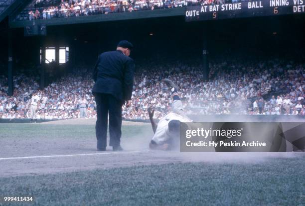 Eddie Yost of the Detroit Tigers collides with Vic Power of the Cleveland Indians as umpire Bill Summers is in position to make the call during an...