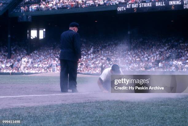 Eddie Yost of the Detroit Tigers collides with Vic Power of the Cleveland Indians as umpire Bill Summers is in position to make the call during an...