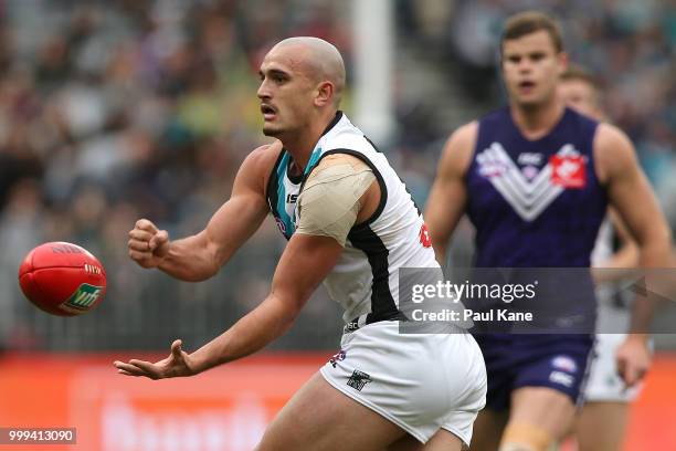 Sam Powell-Pepper of the Power handballs during the round 17 AFL match between the Fremantle Dockers and the Port Adelaide Power at Optus Stadium on...
