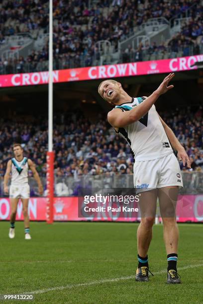 Tom Clurey of the Power reacts after kicking the ball out on the full during the round 17 AFL match between the Fremantle Dockers and the Port...