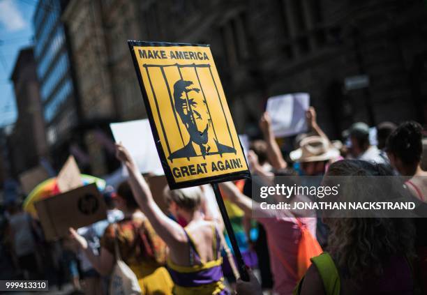 Protester holds a placard featuring US President Donald Trump behinid bars during the so-called "Helsinki Calling" march towards the Senate Square to...