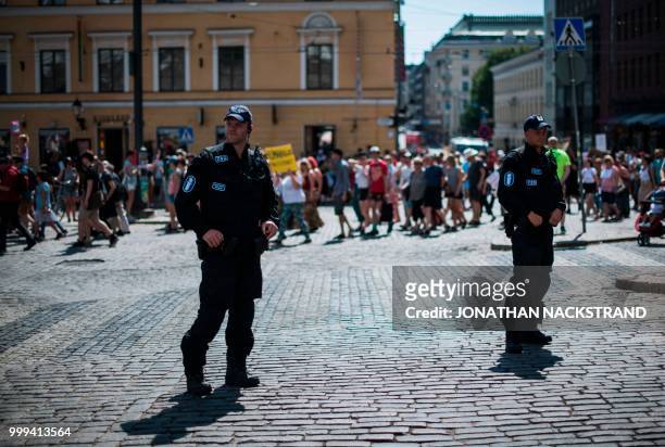 Policemen stand guard during the so-called "Helsinki Calling" march towards the Senate Square to defend the human rights, freedom of speech and...