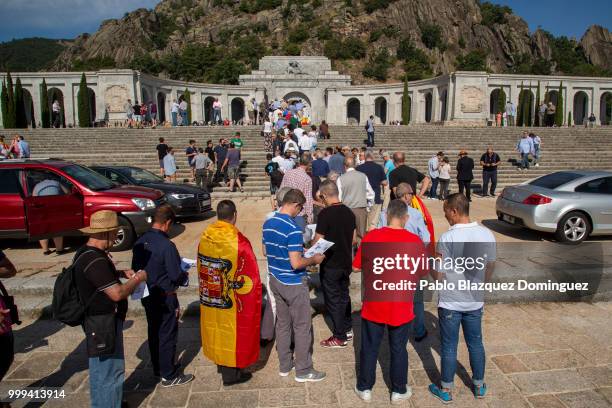 People queue to enter the El Valle de los Caidos monument as one wears a pre-constitutional Spanish flag during a gathering under the slogan 'Don't...