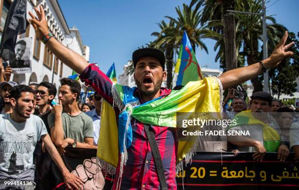 Moroccan draped in the Berber, or Amazigh, flag shouts slogans while marching during a protest against the jailing of Al-Hirak al-Shaabi or "Popular...