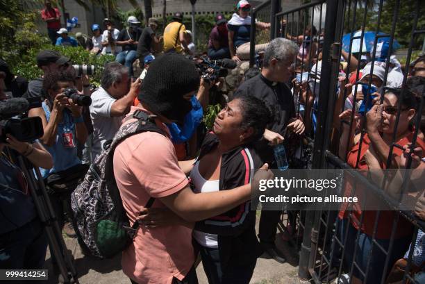 July 2018, Nicaragua, Managua: A hooded student embraces his mother after his arrival at the Cathedral of Nicaragua. During the siege of a church in...