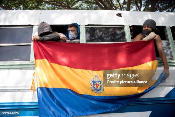 July 2018, Nicaragua, Managua: Masked students hold a banner of the National Autonomous University of the Central American country upon their arrival...