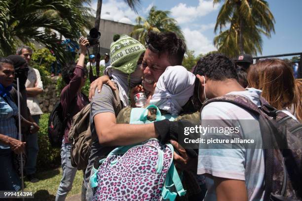 July 2018, Nicaragua, Managua: Masked students meet with relatives and friends as they arrive at the Nicaraguan Cathedral. During the siege of a...