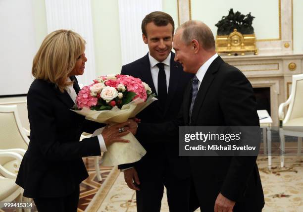 Russian President Vladimir Putin greets French President Emmanuel Macron and his wife Brigitte Macron during their talks at the Kremlin, in Moscow,...