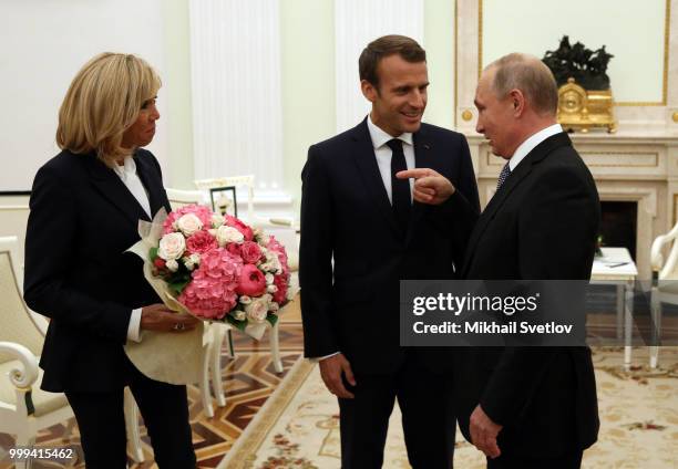 Russian President Vladimir Putin greets French President Emmanuel Macron and his wife Brigitte Macron during their talks at the Kremlin, in Moscow,...