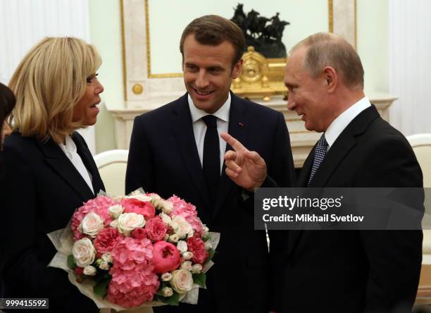 Russian President Vladimir Putin greets French President Emmanuel Macron and his wife Brigitte Macron during their talks at the Kremlin, in Moscow,...