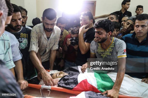 Relatives mourn near the bodies of Palestinian children Amir al-Nimra and Louay Kahil who lost their lives after Israeli army carried out airstrikes,...