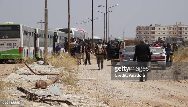 Syrian citizens are seen as they wait to leave Syrias southwestern Daraa province with the 1st convoy on July 15, 2018. The convoy of 15 buses...