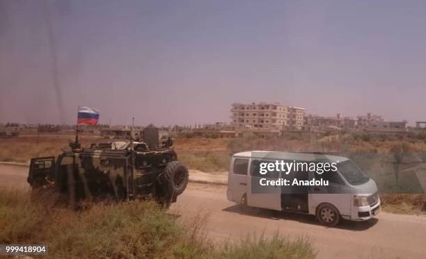 Russian soldiers' armoured vehicle is seen as Syrian citizens leave Syrias southwestern Daraa province with the 1st convoy on July 15, 2018. The...