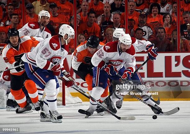Mathieu Darche and Benoit Pouliot of the Montreal Canadiens fights for the puck against James van Riemsdyk of the Philadelphia Flyers in Game 1 of...
