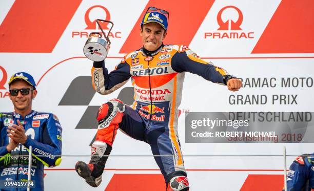 Spanish Honda rider Marc Marquez celebrates in front of second placed Italian Yamaha rider Valentino Rossi on the podium after winning the Moto GP...