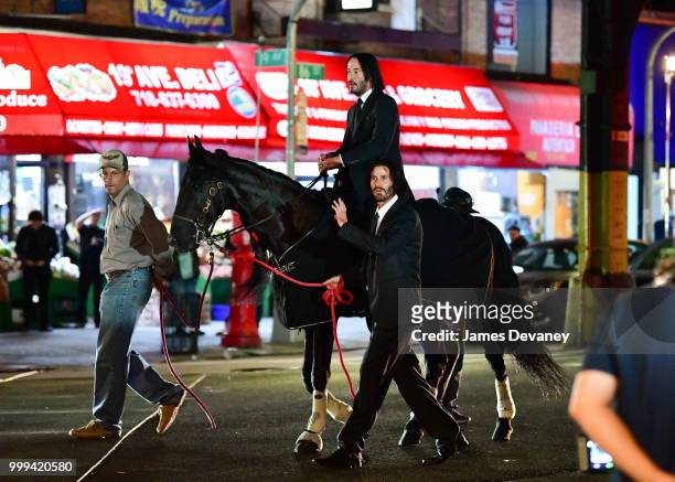 Keanu Reeves and his stunt double seen with a horse on location for 'John Wick 3' in Brooklyn on July 14, 2018 in New York City.