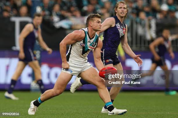 Ollie Wines of the Power handballs during the round 17 AFL match between the Fremantle Dockers and the Port Adelaide Power at Optus Stadium on July...