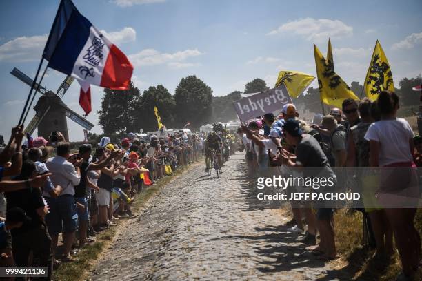 Spectators cheer France's Damien Gaudin leading a two-men breakaway through a cobblestone section during the ninth stage of the 105th edition of the...