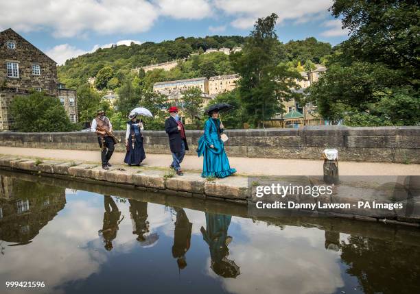 Steampunks are reflected in the River Calder during the Hebden Bridge Steampunk Festival in West Yorkshire.