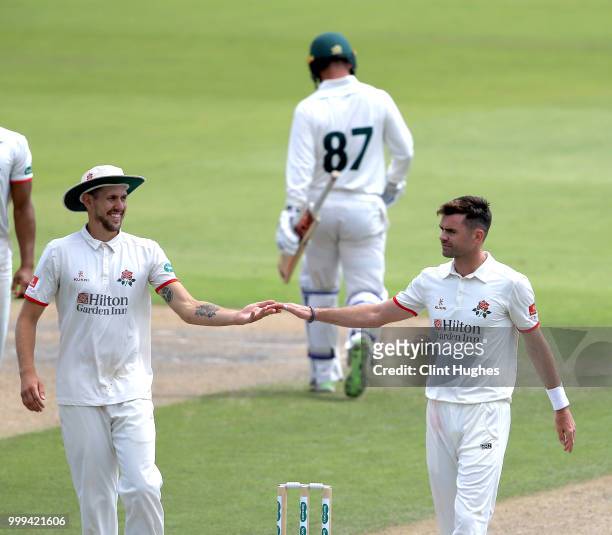 James Anderson of Lancashire celebrates with his team-mate Tom Bailey after taking the wicket of Liam Patterson-White of Nottinghamshire during the...