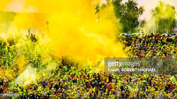 Supporters of Italian Yamaha rider Valentino Rossi light flares during the Moto GP race at the Grand Prix of Germany at the Sachsenring Circuit on...