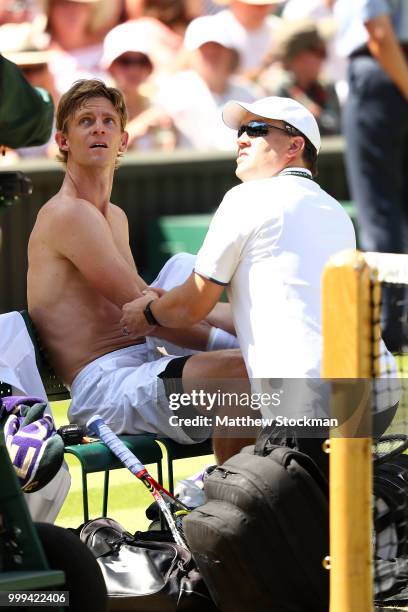 Kevin Anderson of South Africa receives treatment during a break in the Men's Singles final against Novak Djokovic of Serbia on day thirteen of the...