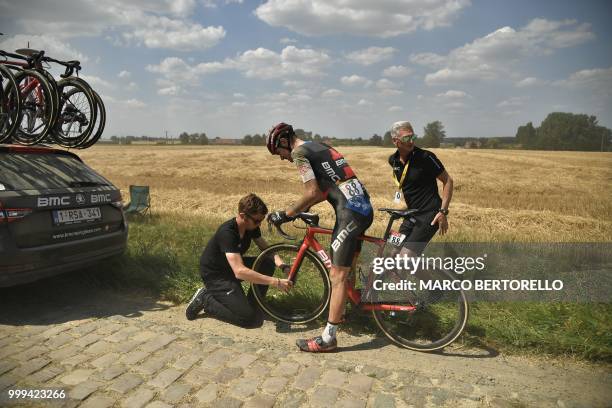 S Tejay Van Garderen changes wheel after suffering a puncture on a cobblestone section during the ninth stage of the 105th edition of the Tour de...