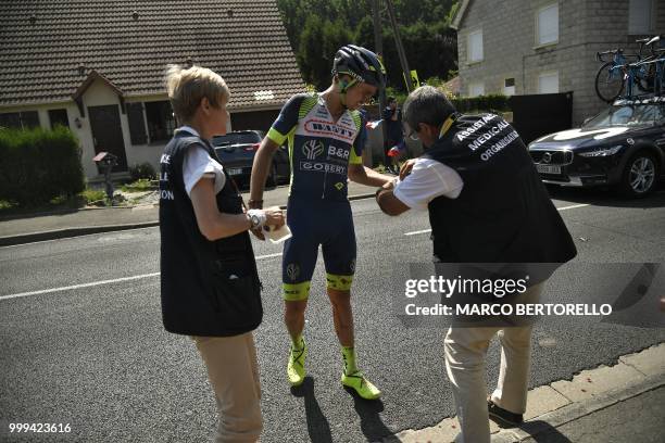 Medic checks New Zealand's Dion Smith left hand after he crashed during the ninth stage of the 105th edition of the Tour de France cycling race...