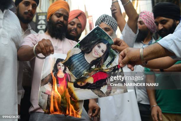 Indian activists of Sikh Foundation group shout slogans as they burn posters of the Bollywood actress Sunny Leone during a protest against the use of...