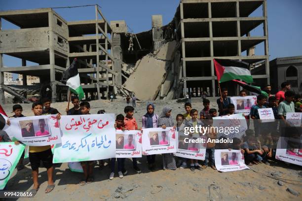 Palestinian children gathering in front of the building which was pounded by Israeli fighter jets and holding pictures of Palestinian children Amir...