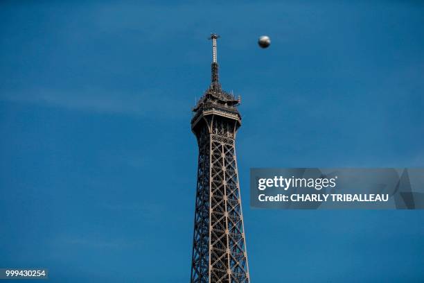 Ball passes next to the Eiffel Tower, prior to the start of the Russia 2018 World Cup final football match between France and Croatia, in Paris on...