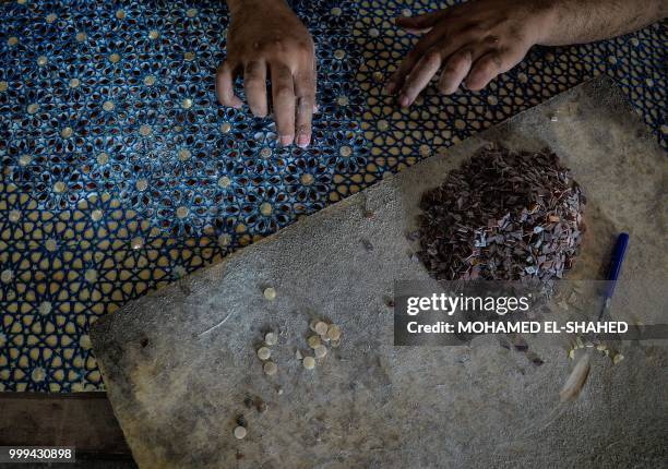 An Egyptian labourer works at a shop specialised in seashell wood inlays in the Saqyat al-Manqadi village in the Egyptian Nile Delta province of...