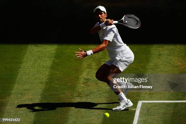 Novak Djokovic of Serbia returns against Kevin Anderson of South Africa during the Men's Singles final on day thirteen of the Wimbledon Lawn Tennis...