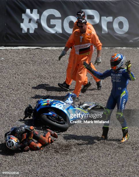 Alex Rins of Spain and Team Suzuki Ecstar reacts after crashing with Pol Espargaro of Spain and Red Bull KTM Team during the MotoGP of Germany at...