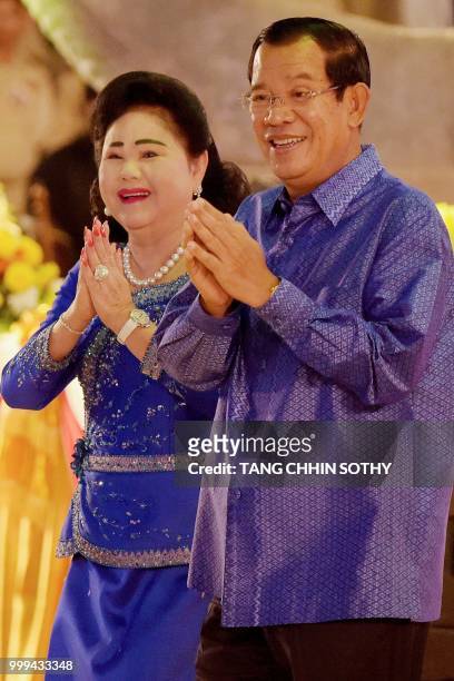 Cambodian Prime Minister Hun Sen and his wife Bun Rany gesture during a ceremony at the Olympic national stadium in Phnom Penh on July 15, 2018. -...