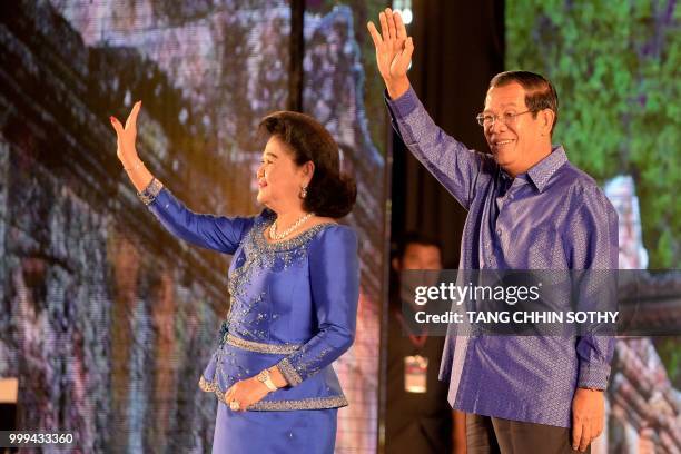 Cambodian Prime Minister Hun Sen and his wife Bun Rany wave during a ceremony at the Olympic national stadium in Phnom Penh on July 15, 2018. - The...