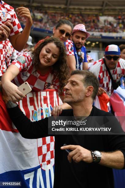 Former Croatia's player and coach Slaven Bilic poses with suppporters ahead of the Russia 2018 World Cup final football match between France and...