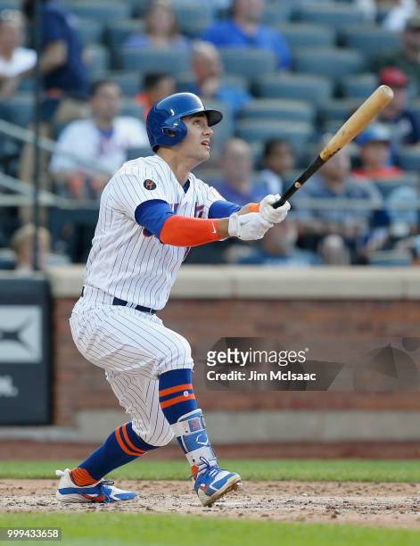 Michael Conforto of the New York Mets follows through on a fifth inning three run home run against the Washington Nationals at Citi Field on July 14,...