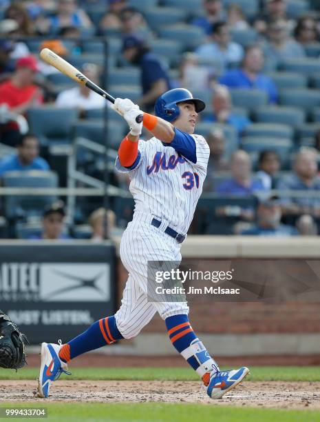 Michael Conforto of the New York Mets follows through on a fifth inning three run home run against the Washington Nationals at Citi Field on July 14,...