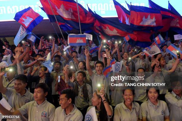 Cambodian students wave national flags and UNESCO flags during a ceremony at the Olympic national stadium in Phnom Penh on July 15, 2018. - The...