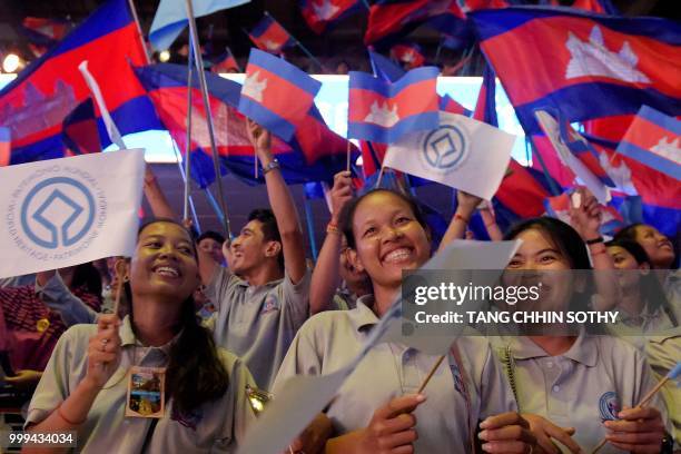 Cambodian students wave national flags during a ceremony at the Olympic national stadium in Phnom Penh on July 15, 2018. - The Cambodian government...