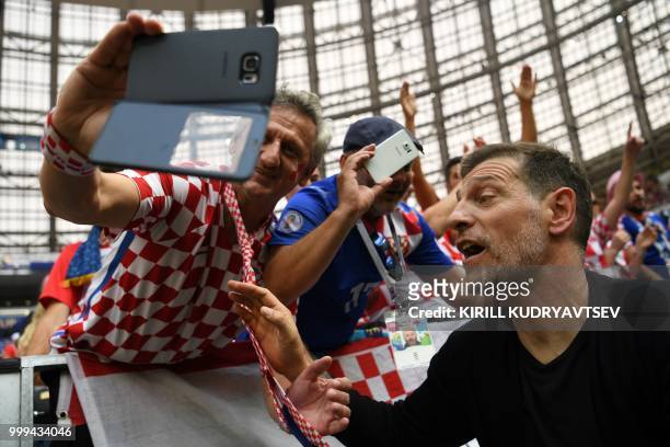 Former Croatia's player and coach Slaven Bilic poses with suppporters ahead of the Russia 2018 World Cup final football match between France and...