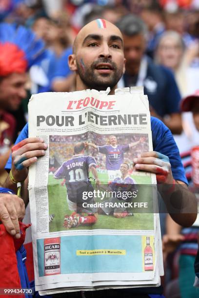 France fan holds a front page of French newspaper L'Equipe before the Russia 2018 World Cup final football match between France and Croatia at the...