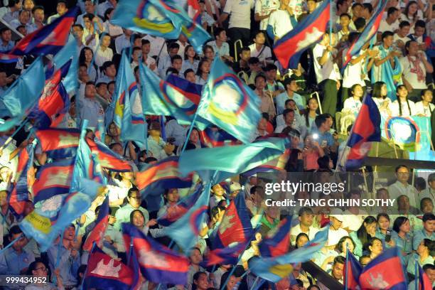 Cambodian students wave national flags during a ceremony at the Olympic national stadium in Phnom Penh on July 15, 2018. - The Cambodian government...